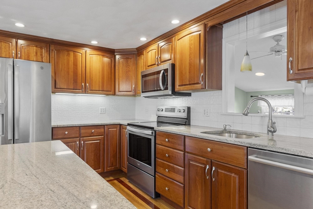 97 Hartwell Road Bedford, MA 01730 - Photo 3 of 42 a kitchen with stainless steel appliances granite countertop wooden cabinets a sink and a refrigerator