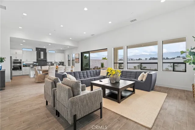 a living room with furniture kitchen and a large window