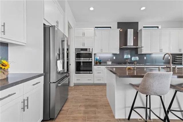 a kitchen with stainless steel appliances granite countertop a refrigerator sink and cabinets