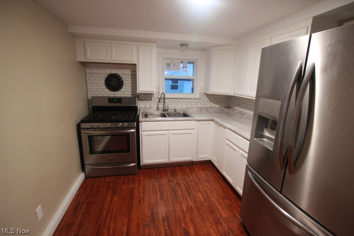 3606 Shelby Road Youngstown, OH 44511 - Photo 4 of 33 Kitchen with sink, tasteful backsplash, stainless steel appliances, dark hardwood / wood-style floors, and white cabinetry