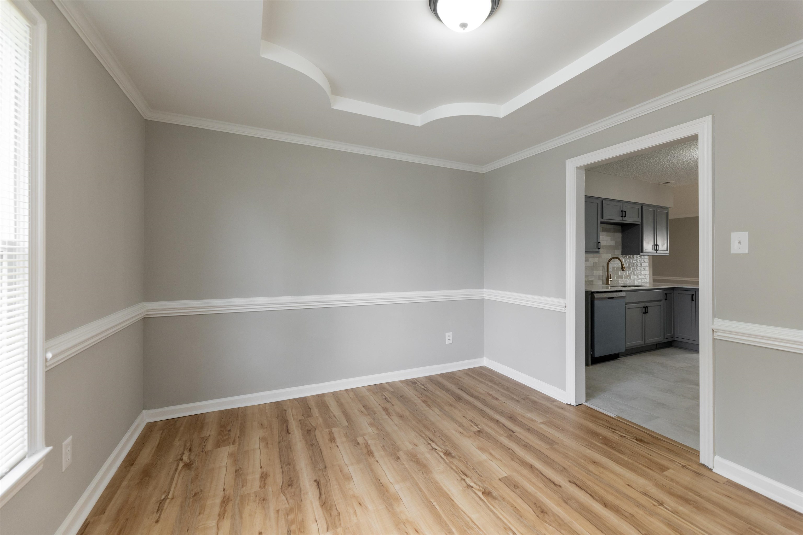 7421 Richmond Road Memphis, TN 38125 - Photo 9 of 39 Spacious interior room featuring wood-finish flooring, chair rail molding, and a decorative tray ceiling