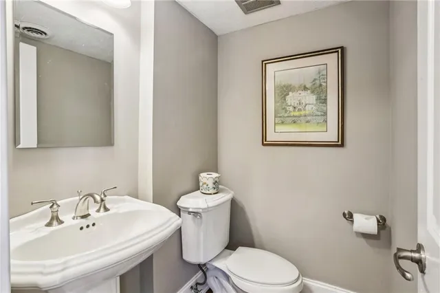 a bathroom with a sink mirror and toilet