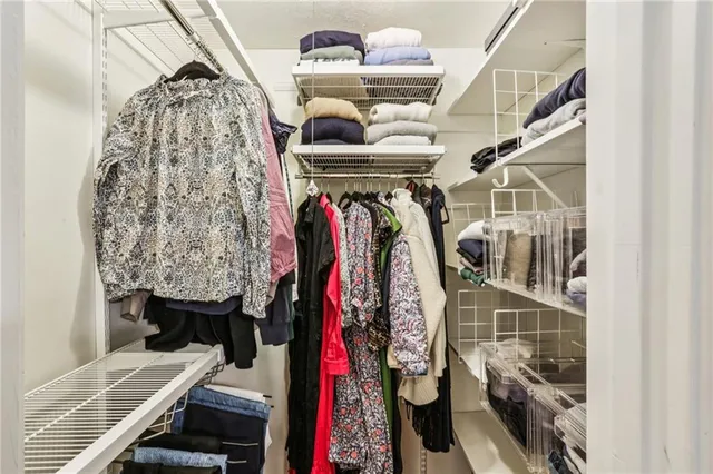 a view of walk in closet with clothes