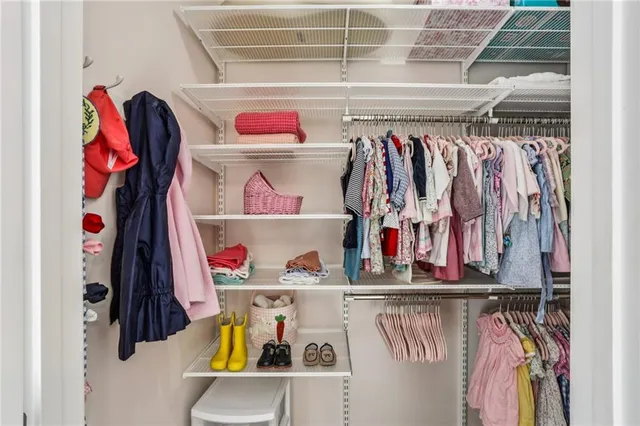 a view of walk in closet with clothes and shoes