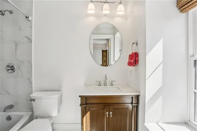a bathroom with a toilet sink and mirror