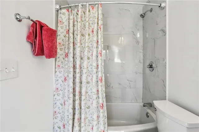 a bathroom with a shower curtain and a toilet
