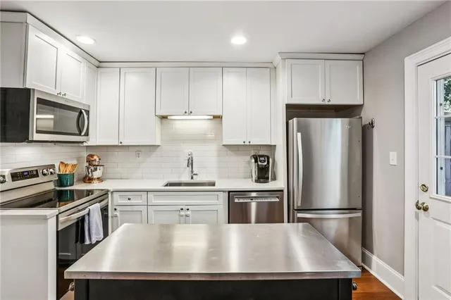 a kitchen with kitchen island a stove a refrigerator and cabinets
