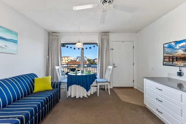 a living room with furniture a flat screen tv and a window