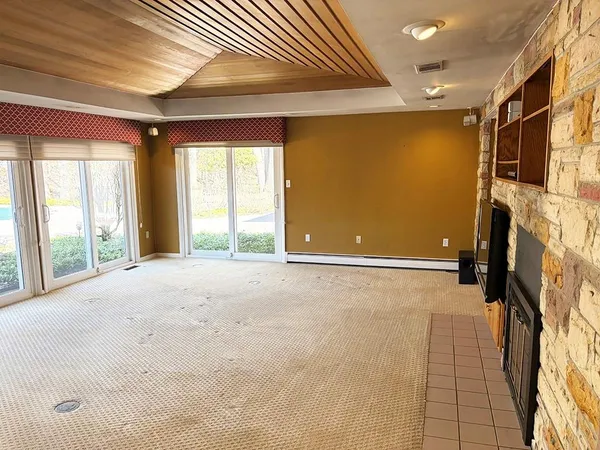 a view of an empty room with a fireplace and a window