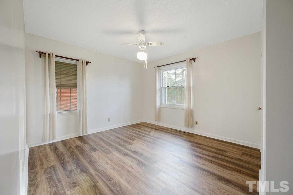 2930 Fairway Drive Raleigh, NC 27603 - Photo 13 of 24 a view of an empty room with wooden floor and a window