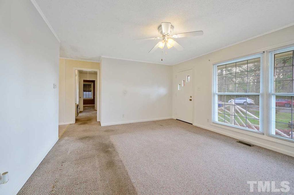 2930 Fairway Drive Raleigh, NC 27603 - Photo 5 of 24 an empty room with chandelier fan and windows