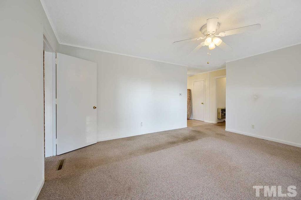 2930 Fairway Drive Raleigh, NC 27603 - Photo 6 of 24 an empty room with a chandelier fan and closet area