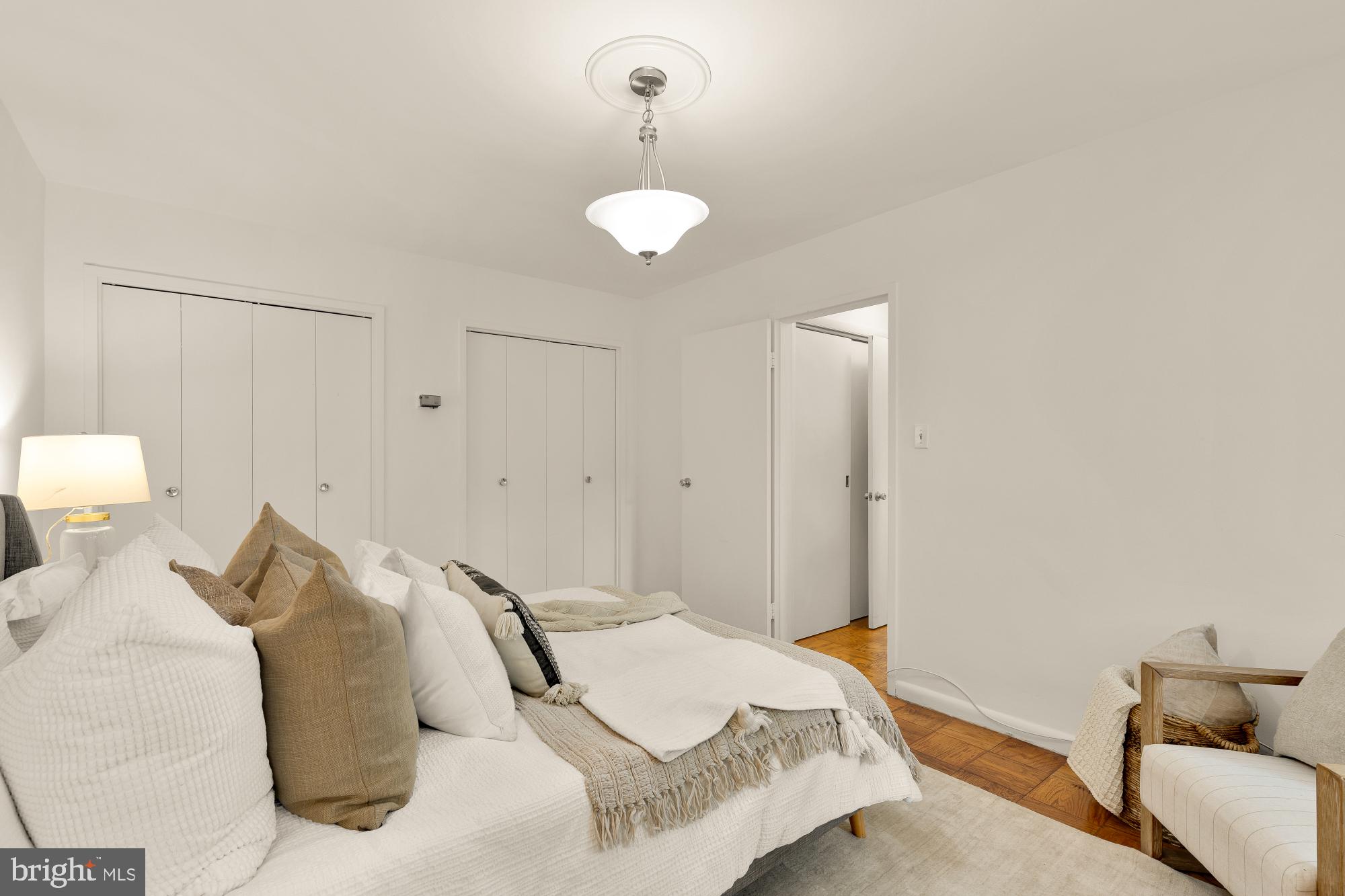 2400 41st Street Northwest, Unit 212 Washington, DC 20007 - Photo 16 of 24 a bedroom with a bed and a chandelier