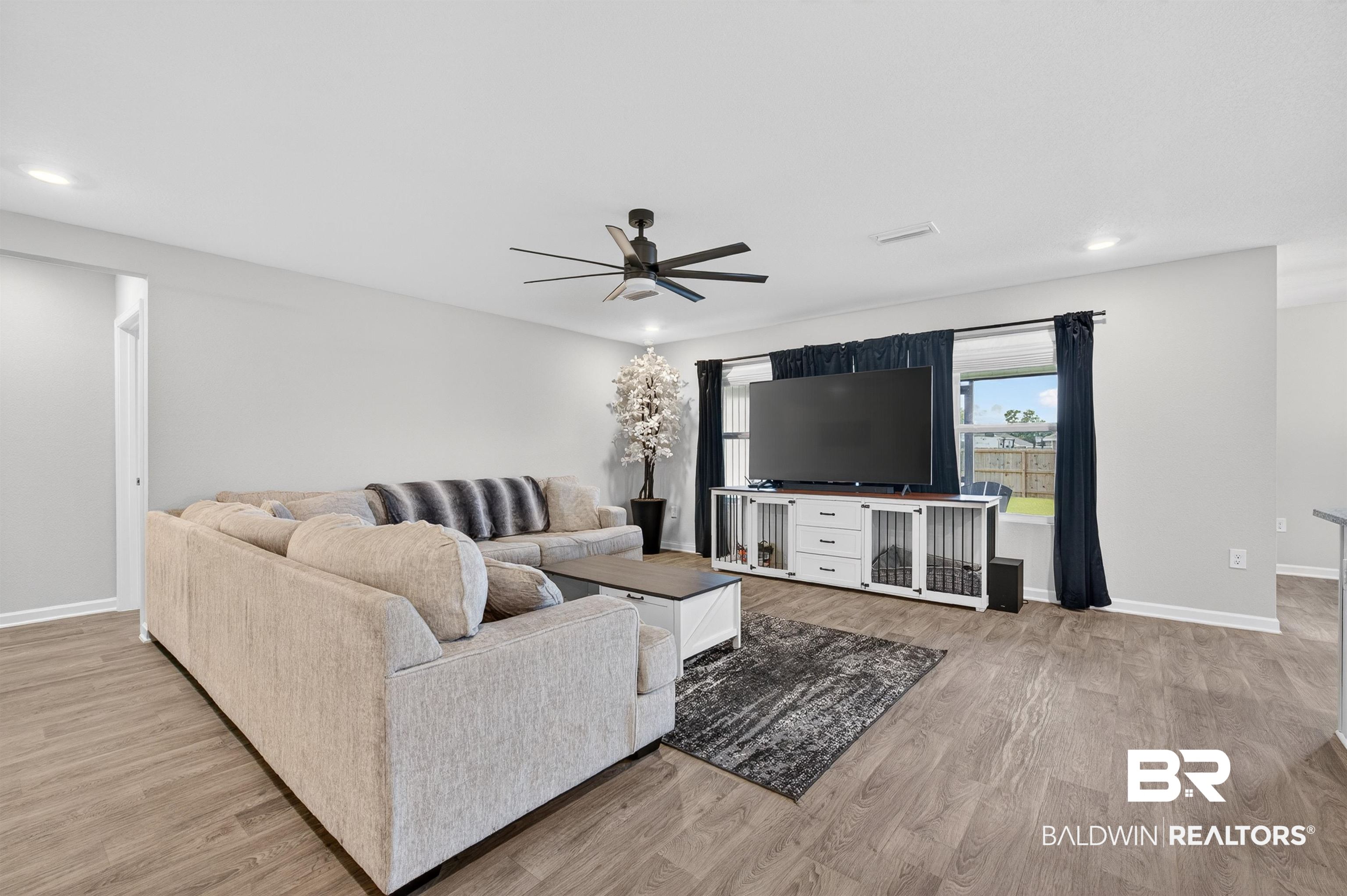 3213 Camino Real Loop Lillian, AL 36549 - Photo 21 of 61 Spacious living area featuring wood-finish flooring, ample natural light from exterior windows, recessed ceiling lighting, and a contemporary ceiling fan