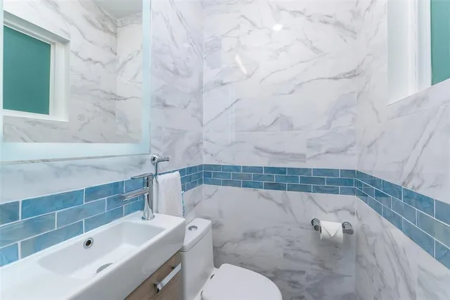 a front view of a house with a garden and trees