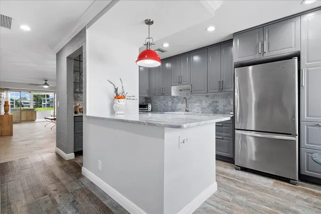 a kitchen with kitchen island a counter space a sink appliances and cabinets