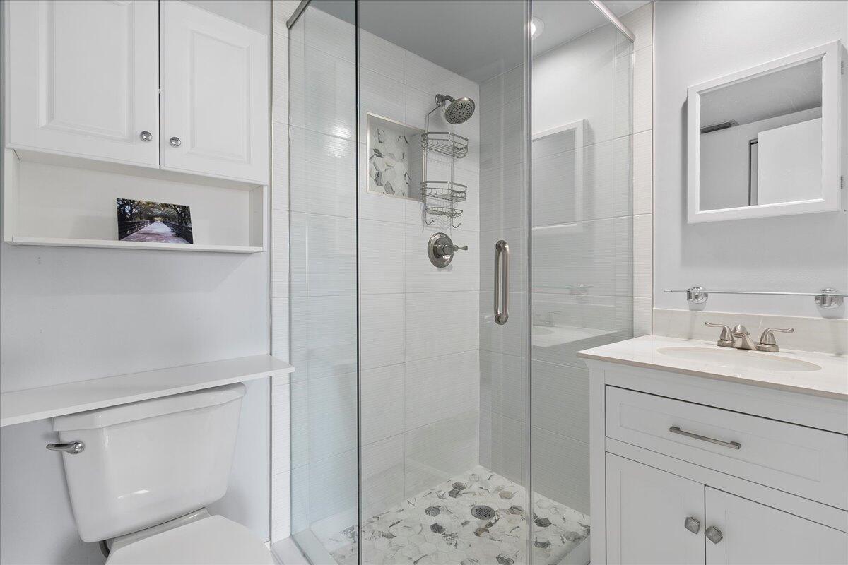 1395 Southwest 27th Avenue, Unit 103 Delray Beach, FL 33445 - Photo 14 of 26 a bathroom with a sink a toilet and shower