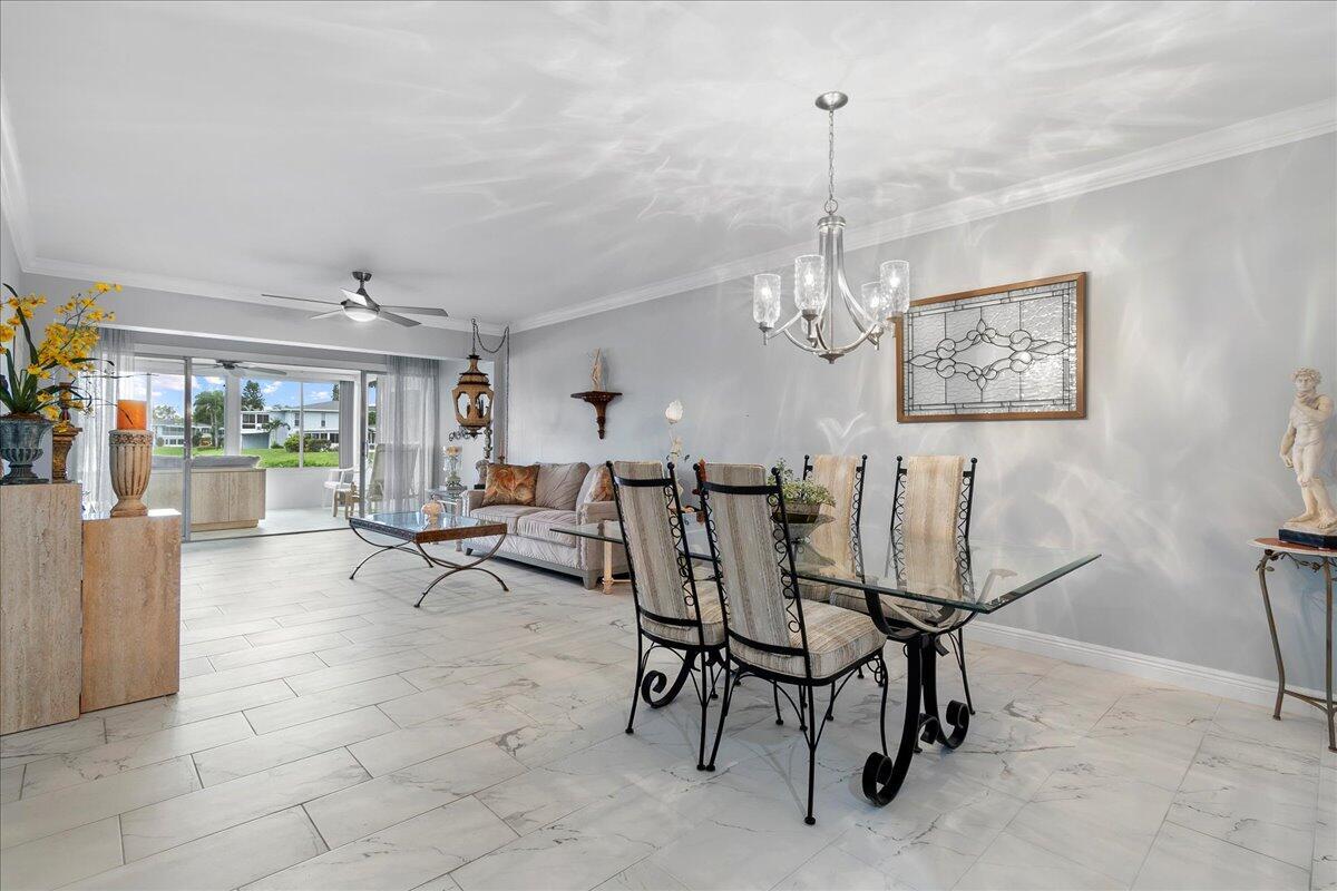 1395 Southwest 27th Avenue, Unit 103 Delray Beach, FL 33445 - Photo 15 of 26 a view of a dining room with furniture and a chandelier