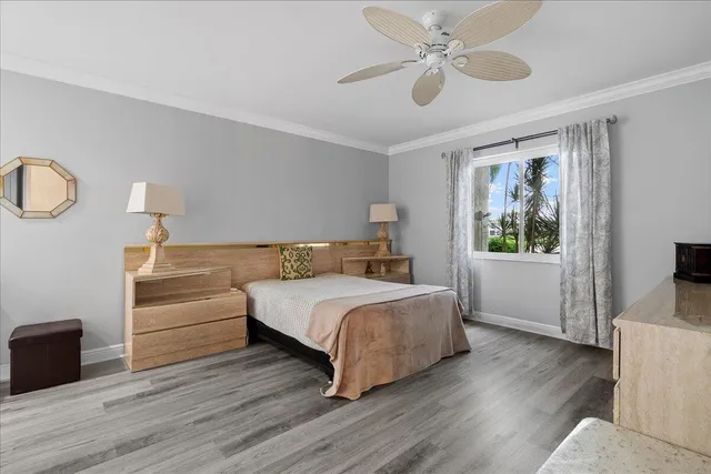 a bedroom with a bed and a dresser with wooden floor