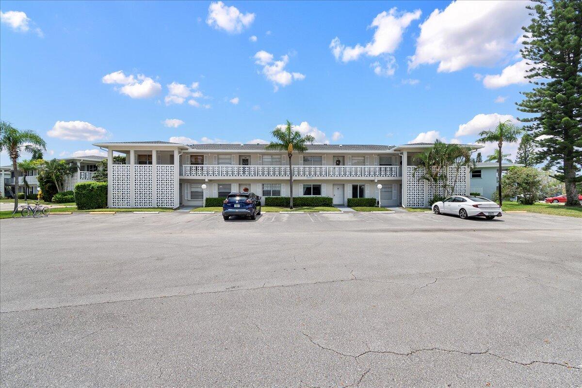 1395 Southwest 27th Avenue, Unit 103 Delray Beach, FL 33445 - Photo 3 of 26 a car parked in front of a building