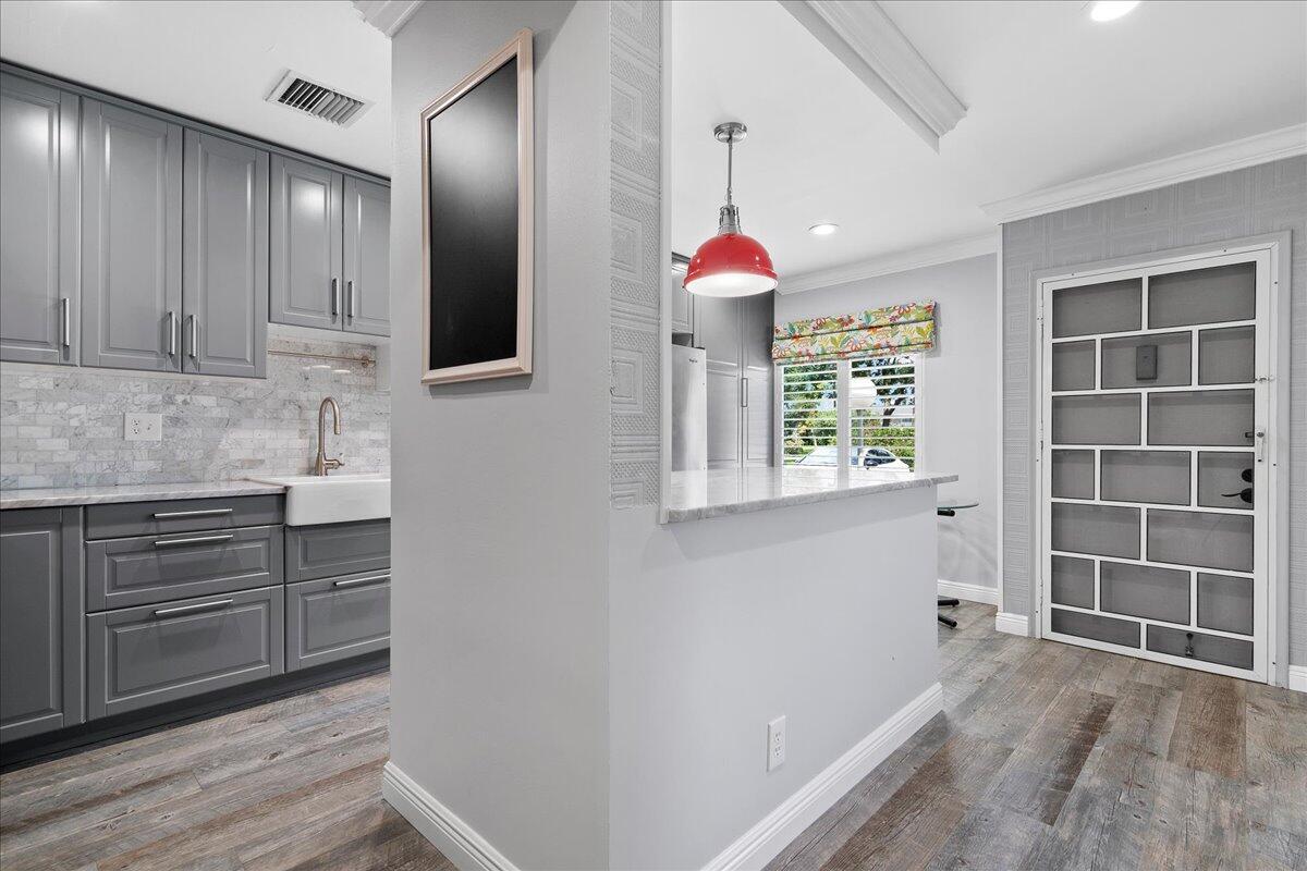 1395 Southwest 27th Avenue, Unit 103 Delray Beach, FL 33445 - Photo 7 of 26 a kitchen with cabinets and window