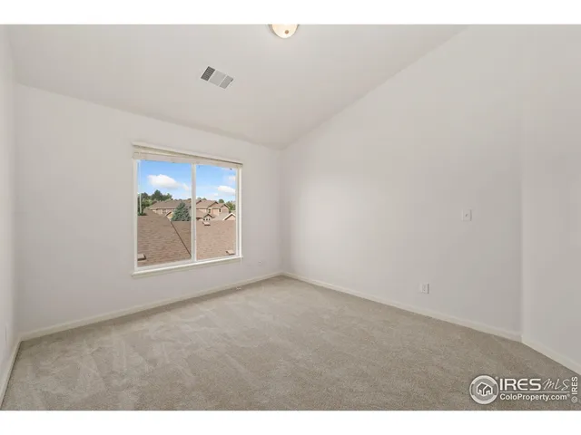 a bathroom with a granite countertop sink a toilet a mirror and window