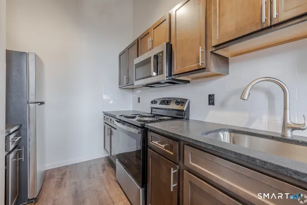 a kitchen with stainless steel appliances granite countertop a stove top oven a sink and dishwasher