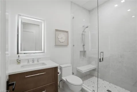 a bathroom with a sink a toilet and shower