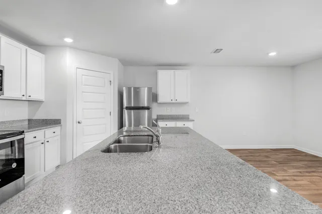 a kitchen with sink refrigerator and cabinets