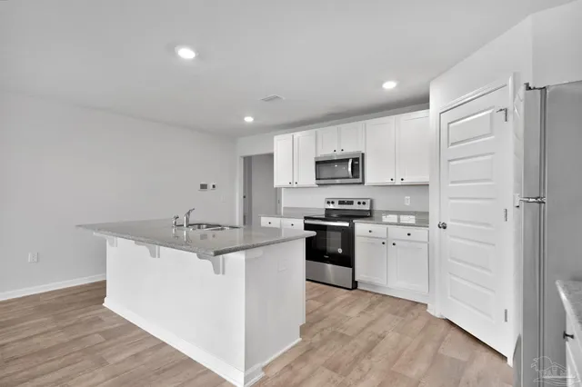 a kitchen with stainless steel appliances granite countertop a refrigerator and a stove top oven