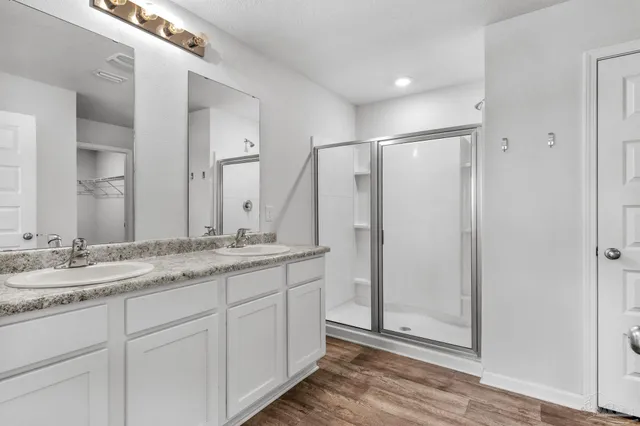 a bathroom with a granite countertop sink two mirror and a