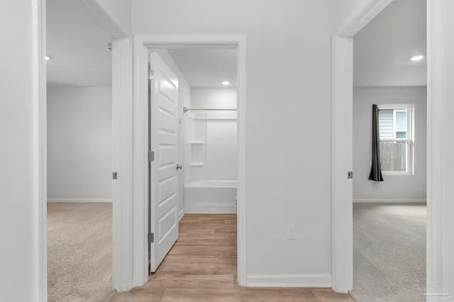 a view of a hallway with wooden floor