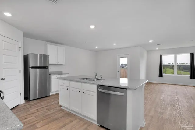 a kitchen with stainless steel appliances granite countertop a refrigerator and a stove
