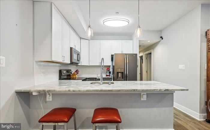 1340 Nicholson Street Northwest, Unit 2 Washington, DC 20011 - Photo 2 of 16 a kitchen with stainless steel appliances granite countertop a sink a refrigerator and a wooden cabinets