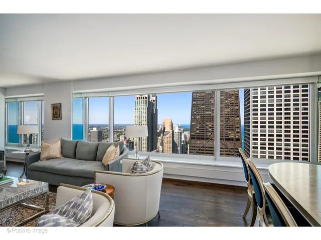 a living room with furniture a rug and a floor to ceiling window