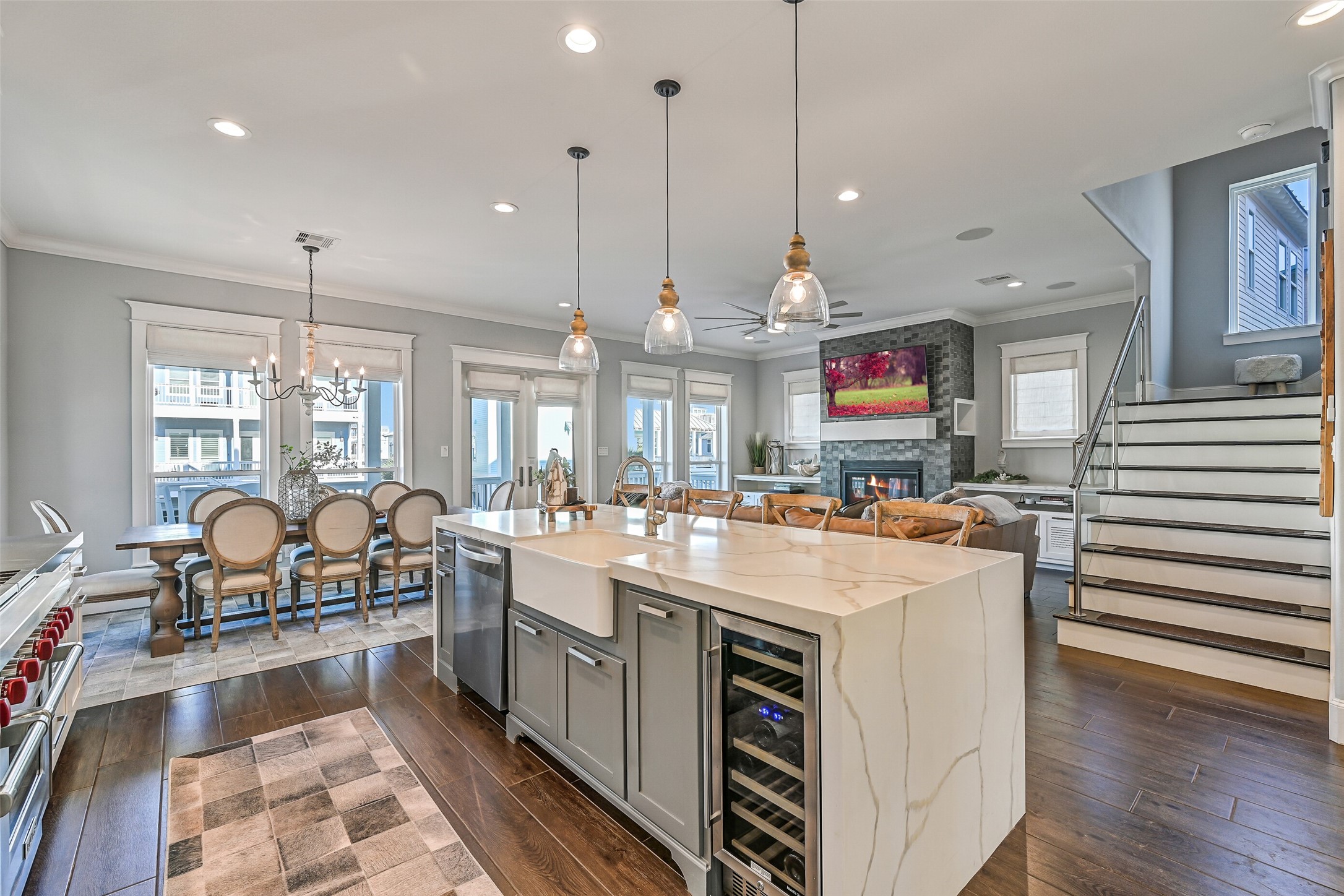 3839 Periwinkle Galveston, TX 77554 - Photo 7 of 49 Designed for both function and style, the kitchen offers a large island with quartz waterfall countertops, seating for 4, pendant lighting, and large tile plank flooring that flows throughout the space.