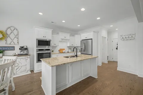a kitchen with stainless steel appliances granite countertop a sink stove and refrigerator
