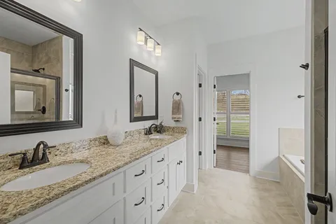 a bathroom with double sink and two mirror