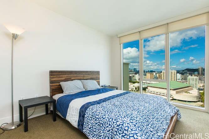 1837 Kalakaua Avenue, Unit 2505 Honolulu, HI 96815 - Photo 7 of 10 a bed sitting in a bedroom next to a large window