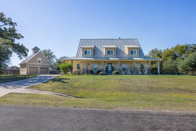 a front view of a house with a yard and trees
