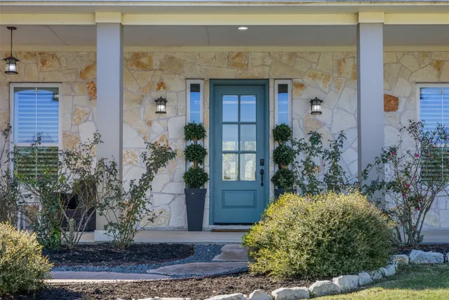 a front view of a house with plants