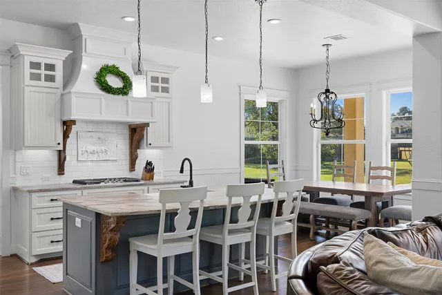 a kitchen with a table chairs a sink and a window