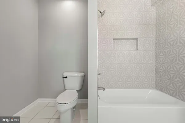 an empty room with wooden floor chandelier fan and windows