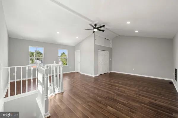 a living room with furniture kitchen and a wooden floor