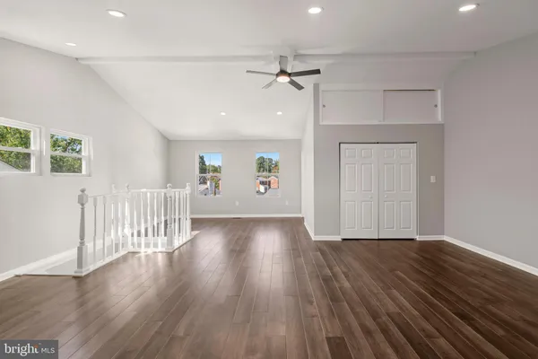 a kitchen with a sink stove and white cabinets with wooden floor