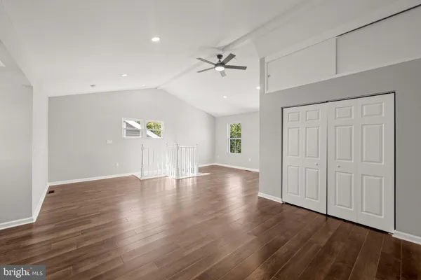 a kitchen with a stove a sink a refrigerator and white cabinets with wooden floor