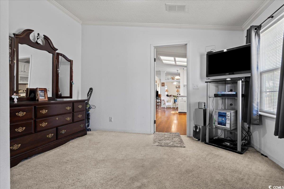 1130 Buck Swamp Road Fork, SC 29543 - Photo 11 of 35 Bedroom with carpet floors, a textured ceiling, visible vents, and crown molding