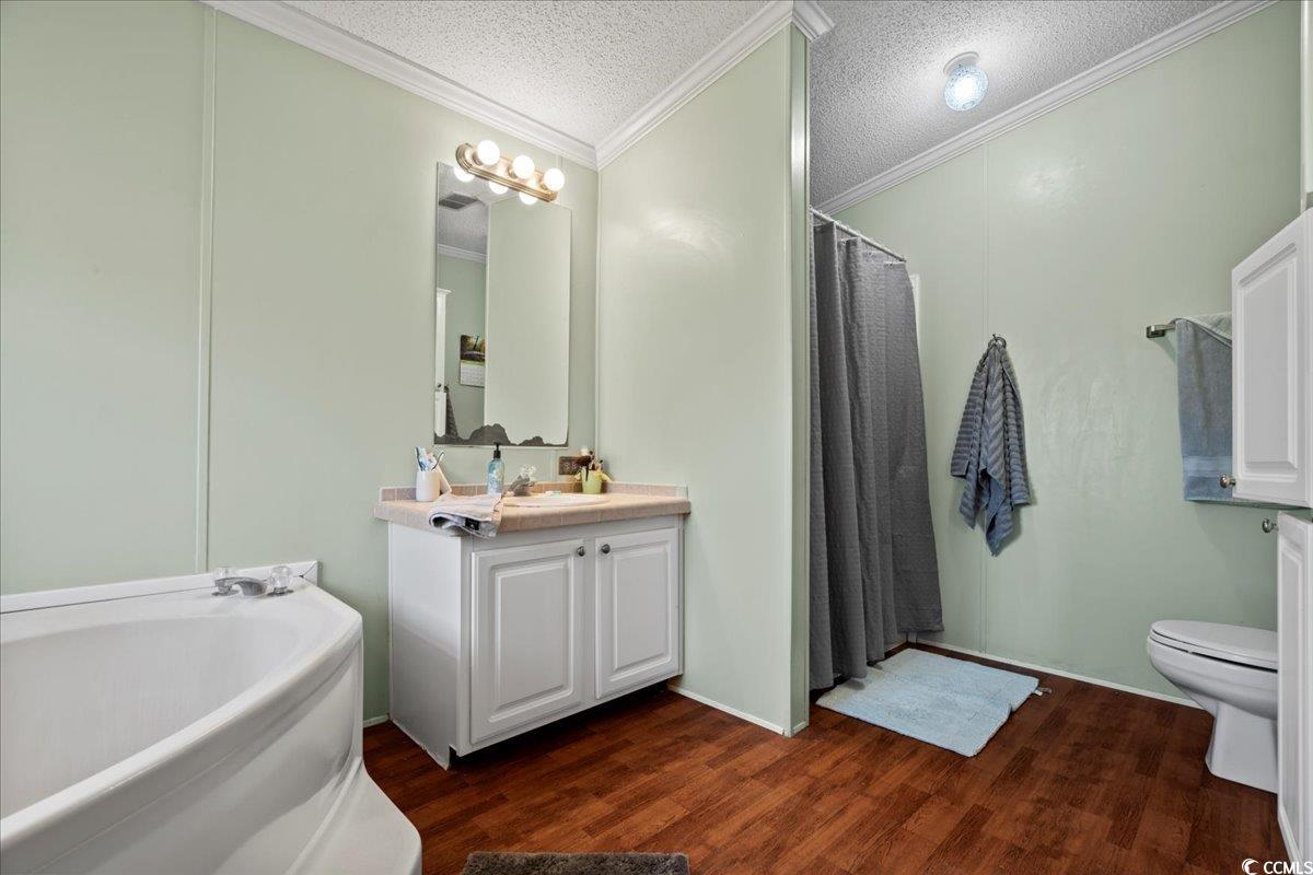 1130 Buck Swamp Road Fork, SC 29543 - Photo 15 of 35 Full bath featuring a textured ceiling, wood finished floors, toilet, and crown molding