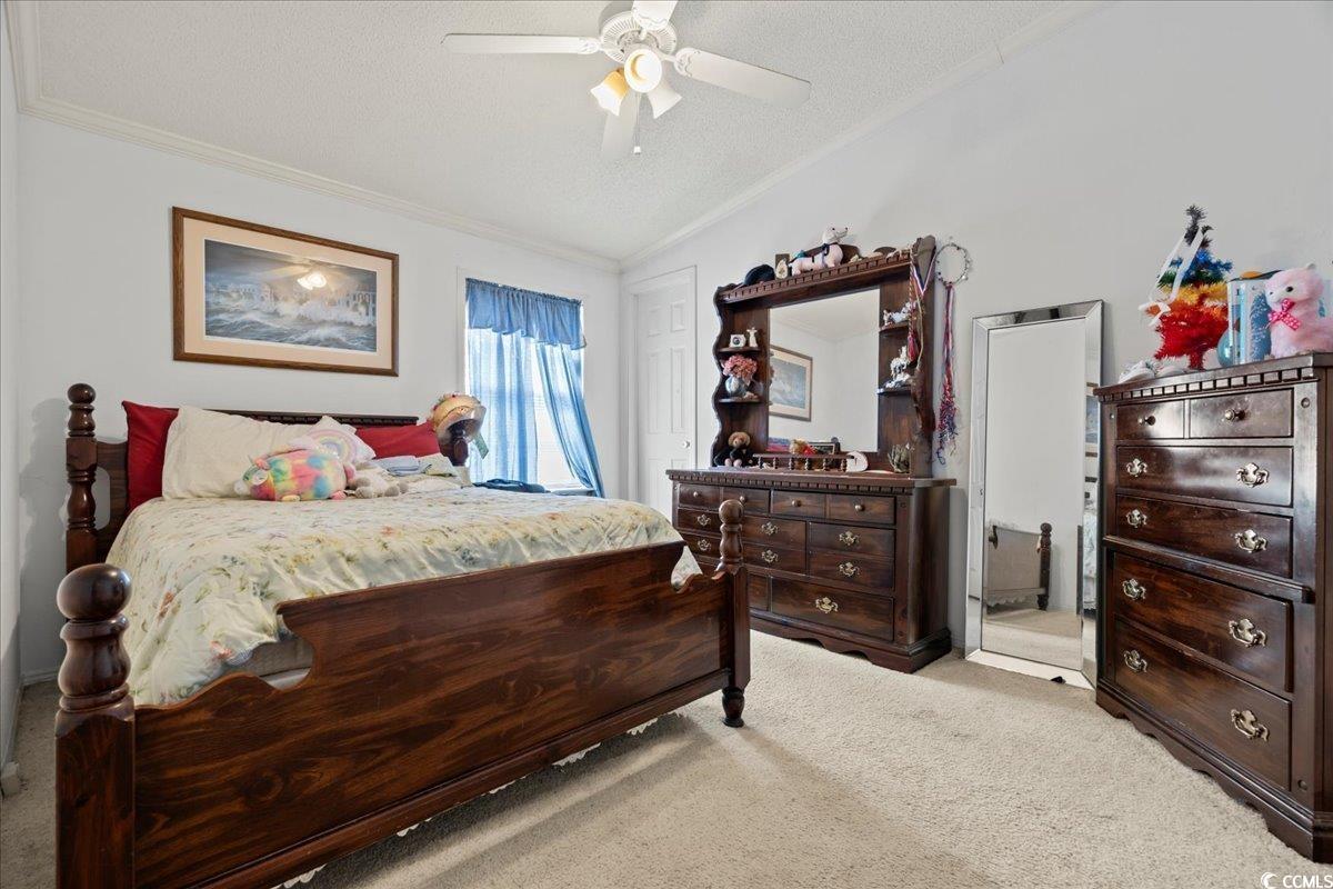 1130 Buck Swamp Road Fork, SC 29543 - Photo 20 of 35 Carpeted bedroom with a textured ceiling, ornamental molding, vaulted ceiling, and ceiling fan