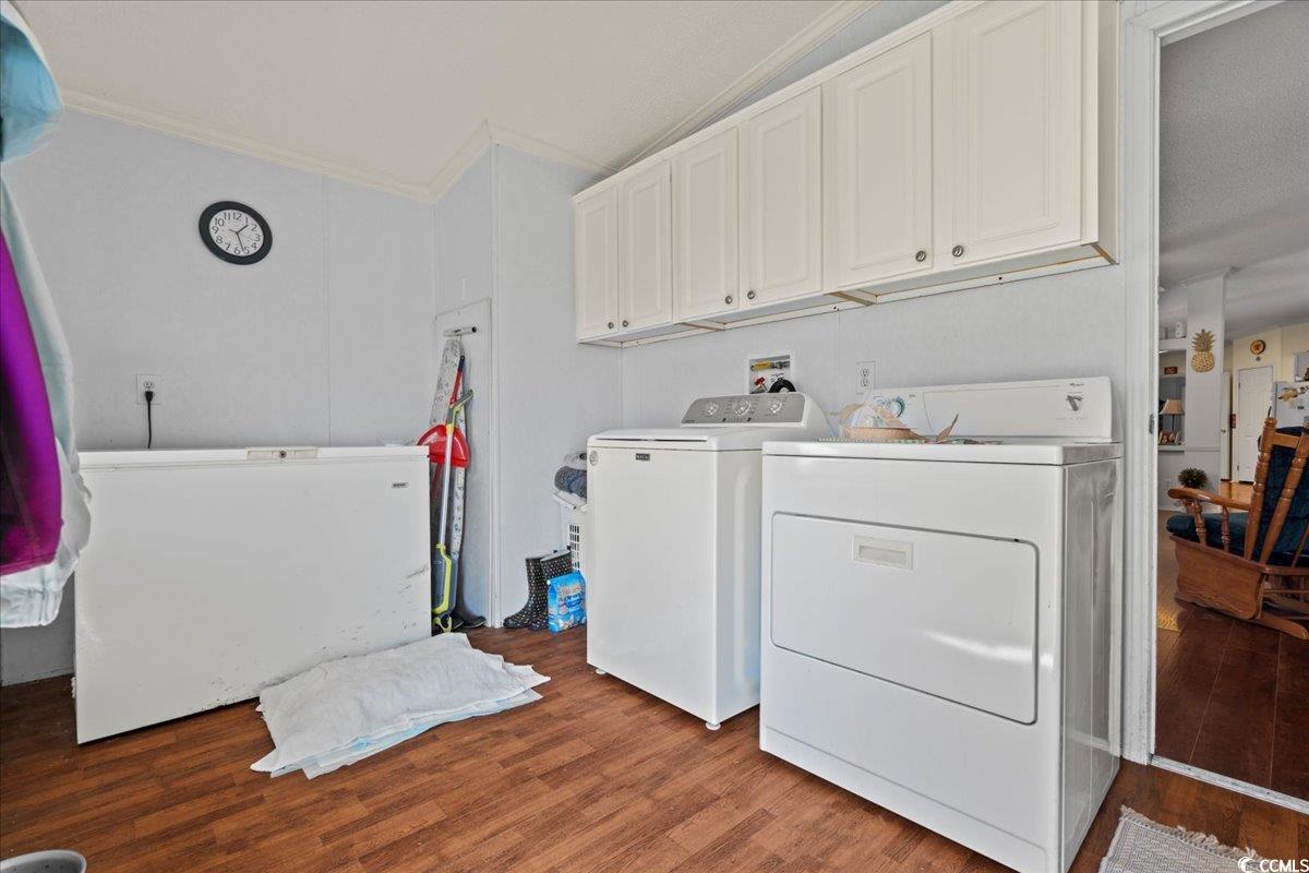 1130 Buck Swamp Road Fork, SC 29543 - Photo 23 of 35 Laundry room with crown molding, washer and dryer, wood finished floors, and cabinet space